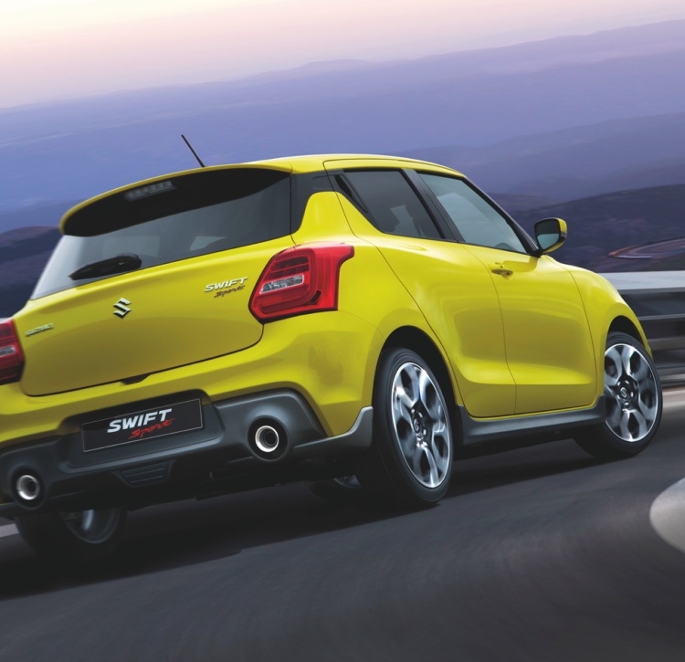 Yellow Swift Sport rear view on winding road