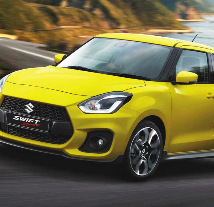 Yellow Swift Sport on ocean road